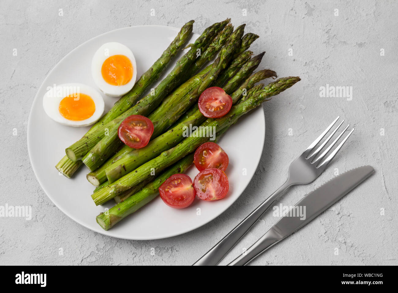 Gebackene grüne Spargel, frischen Tomaten und gekochte Eier mit ...