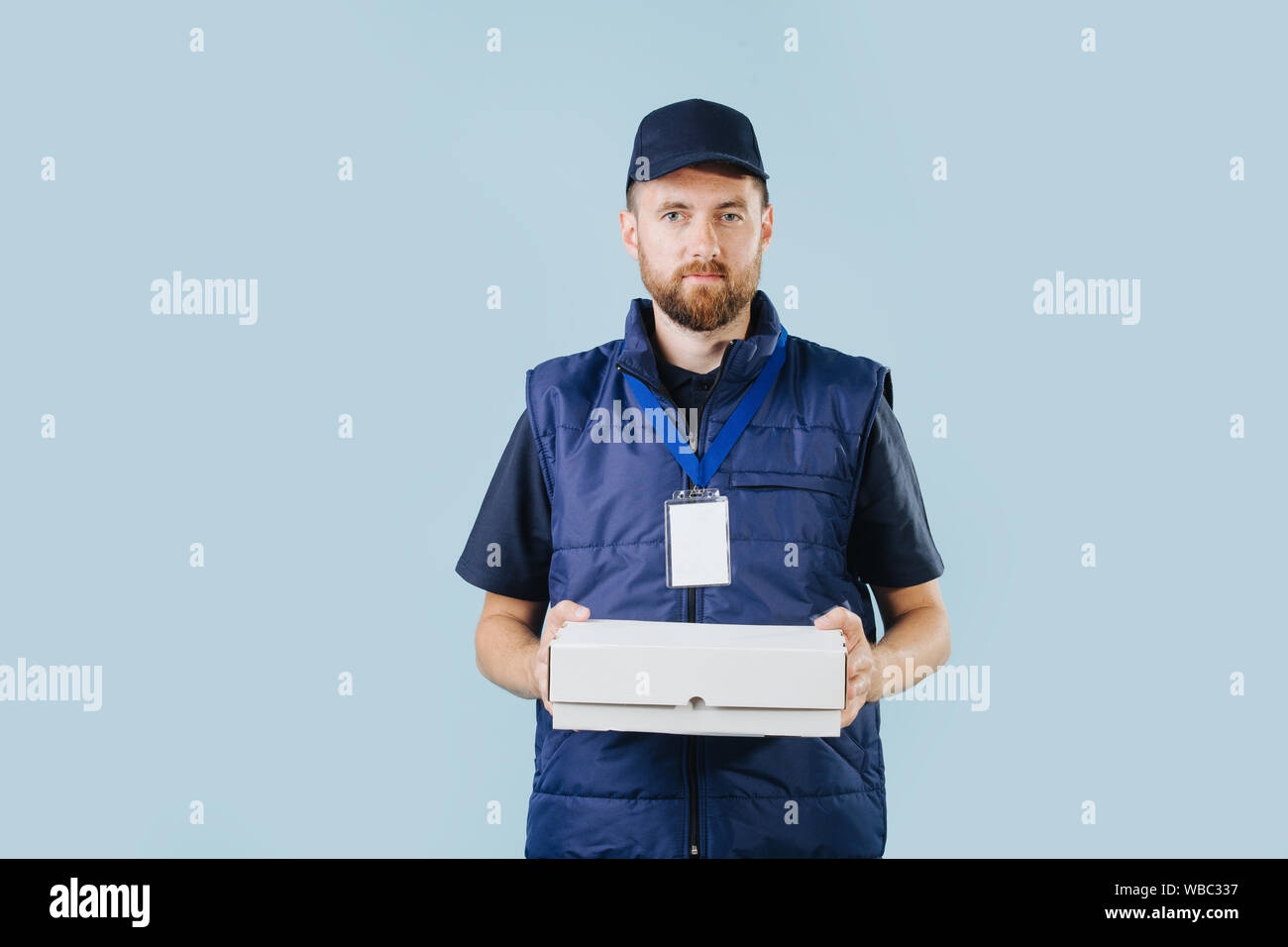 Lieferung Mann in Uniform hält weiß Karton Stockfoto