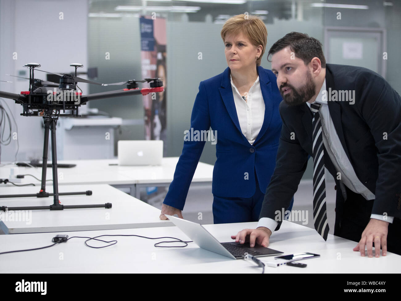 Erster Minister von Schottland Nicola Sturgeon erfüllt Doktorand John Pedro Battistella Nadas bei einem Besuch in der Schule der Technik an der Universität von Glasgow, wo die schottische Regierung ein neues 5G-Plan vorgestellt. Stockfoto