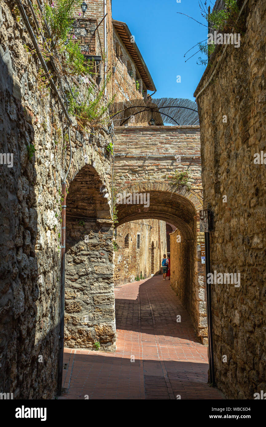 Schmale Gasse terrakottaböden von San Gimignano. Stockfoto