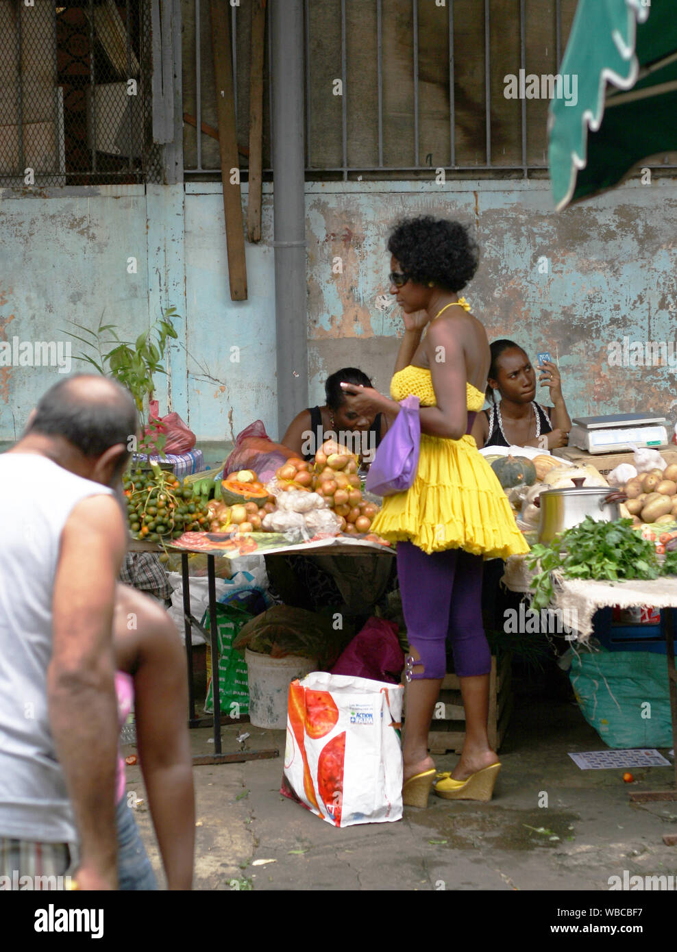 Cayenne, Französisch-Guayana - 3.06.2010 - Stilvoll gekleidete Frau. Rambutan Jahreszeit in Wochenende Markt. Stockfoto