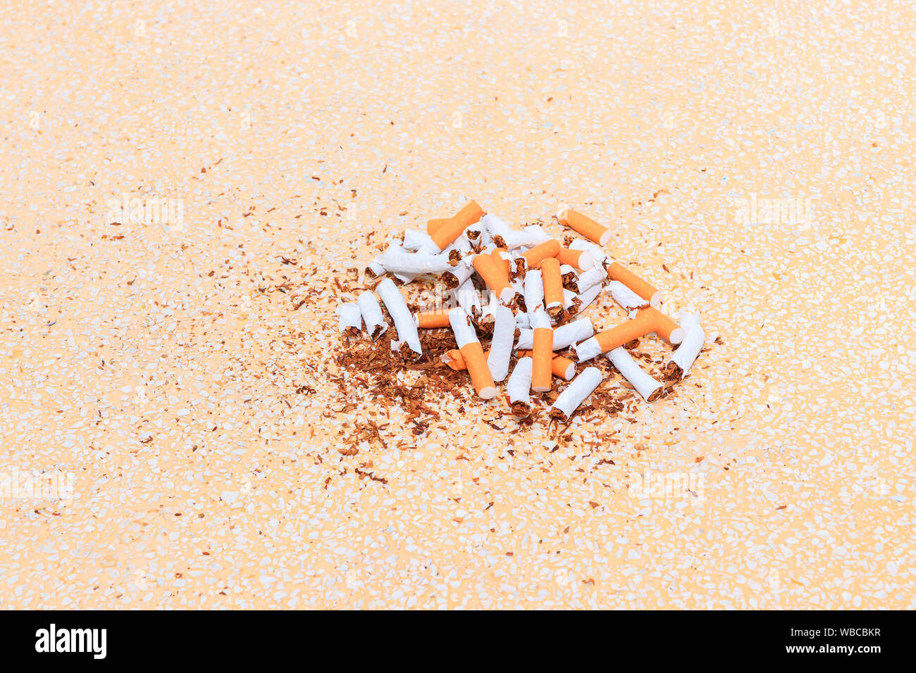 Stapel Zigaretten auf dem Tisch terrazzo Bodenbelag gelben Hintergrund gebrochen. health care Konzept, das Rauchen aufzugeben. Stockfoto