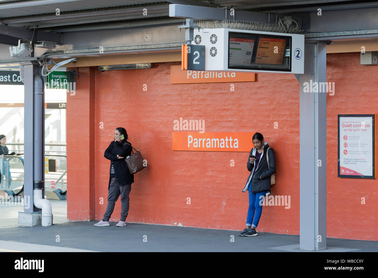 Mit einer elektronischen Anzeigetafel und neue Stahlkonstruktionen vor Menschen stehen in der Nähe des Heritage ursprünglichen Mauer Parramatta Bahnhof aufgeführt Stockfoto