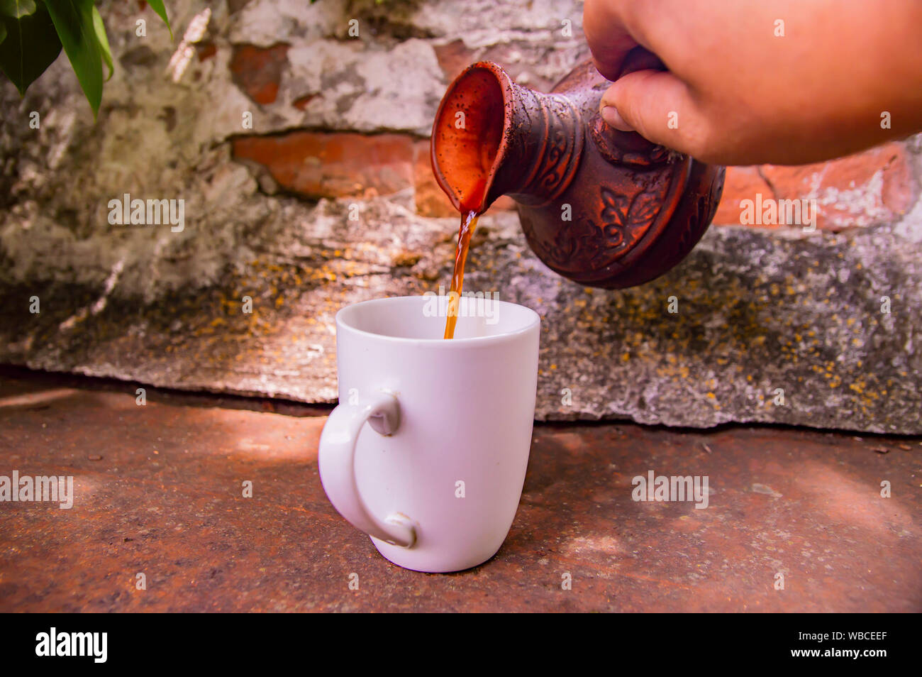 Ton Turk für Kaffee und eine weiße Schale auf die Wand im Hintergrund. Hintergrund. Stockfoto