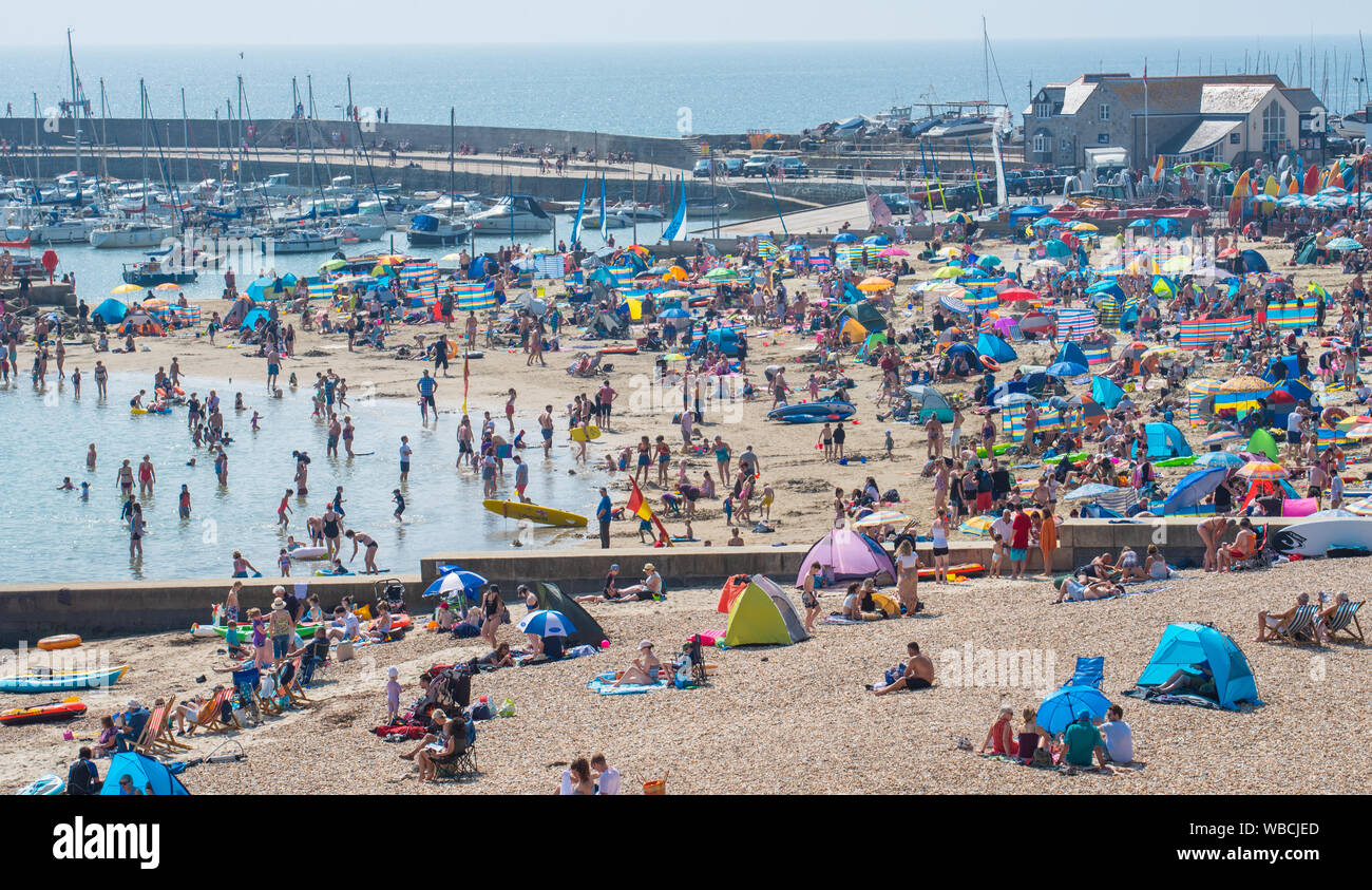 Lyme Regis, Dorset, Großbritannien. 26 Aug, 2019. UK Wetter: Massen von strandgängern strömen zu den Seaside Resort von Lyme Regis in der Sonne an einem anderen Tag der glühend heiße Sonne und rekordverdächtige tenperatures Aalen. Der Strand ist wieder eingepackt wie die steigenden Temperaturen gesetzt sind dies der heißeste August Bank Holiday zu machen seit Beginn der Aufzeichnungen. Credit: Celia McMahon/Alamy leben Nachrichten Stockfoto