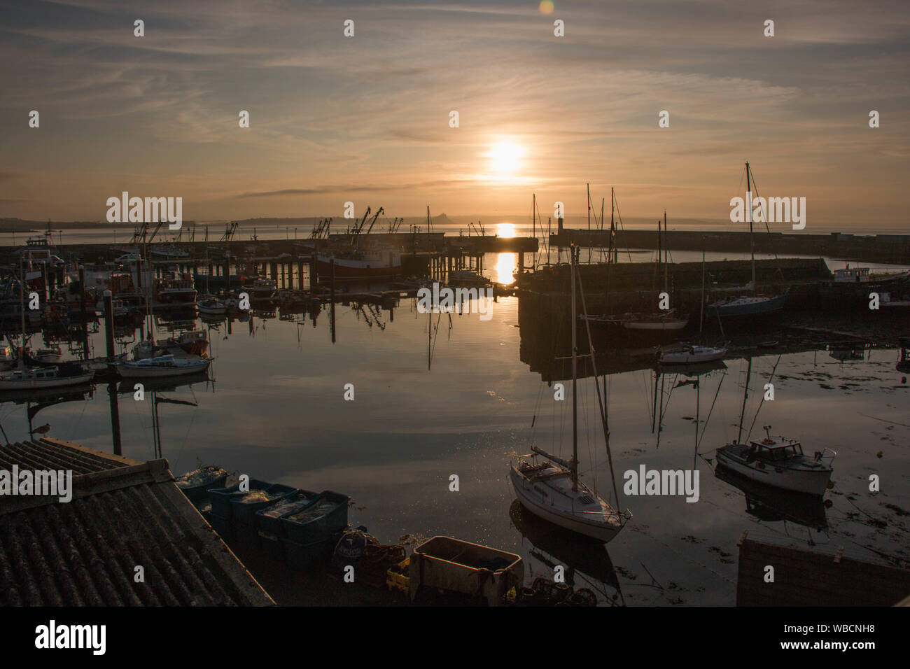 Silhouetten von Yachten in Newlyn Harbour, Cornwall, bei Sonnenaufgang Stockfoto