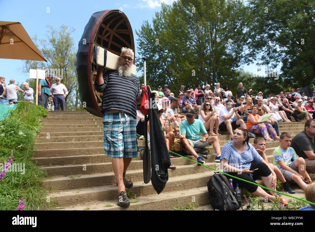 Ironbridge, Shropshire, Großbritannien, 26. August 2019. Bank Holiday Menge zusehen, wie ein anderer Wettbewerber für das Wasser Leiter der jährlichen Ironbridge Coracle Regatta auf dem Fluss Severn. Quelle: David Bagnall/Alamy leben Nachrichten Stockfoto