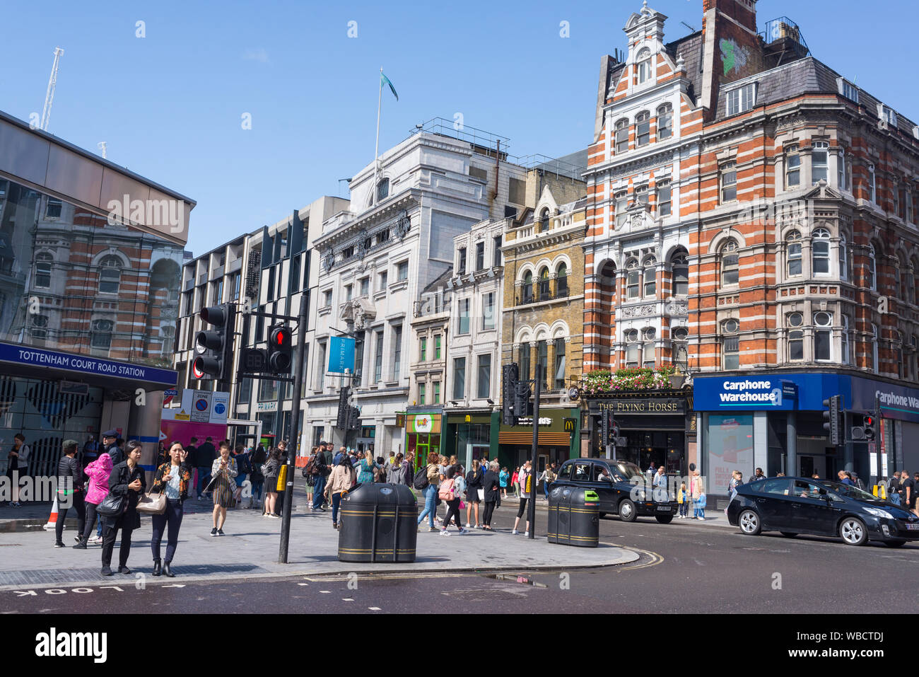 London, UK - August 2019: geschäftigen Kreuzung mit Fußgängern Touristen und Autos vor Station Tottenham Court Road, London, UK Stockfoto
