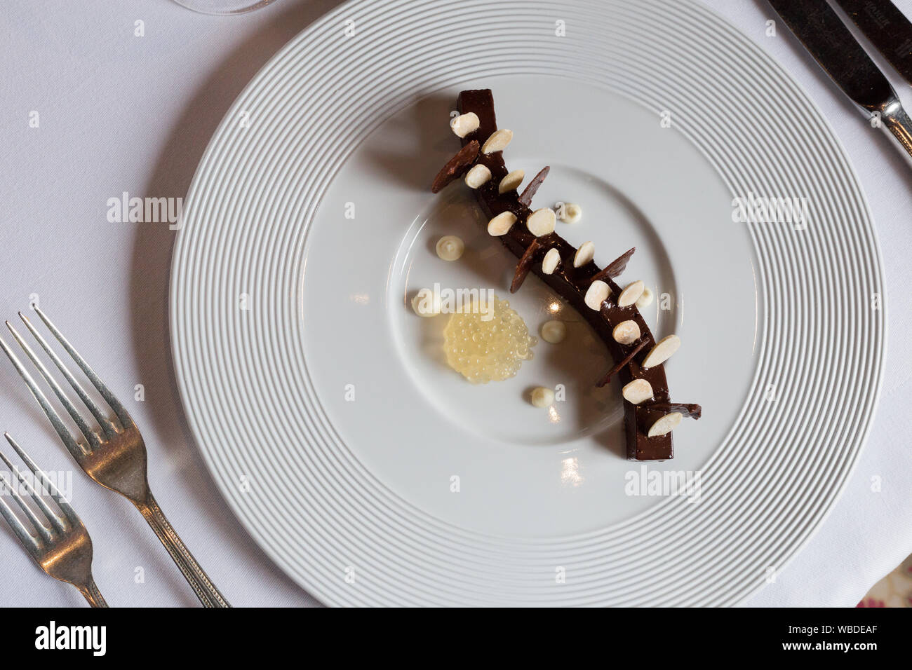 Dessert aus Schokoladenganache mit Apfelkaviar, Mascarpone und gezuckerten Mandeln Stockfoto