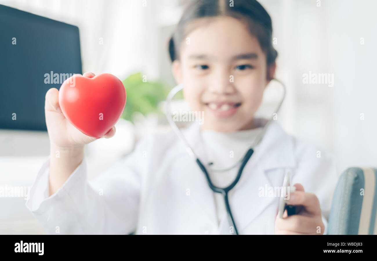 Herz in den Händen von den niedlichen Kind in Arzt Mantel mit Stethoskop. Liebe Konzept. Gesundheit Konzept. Stockfoto