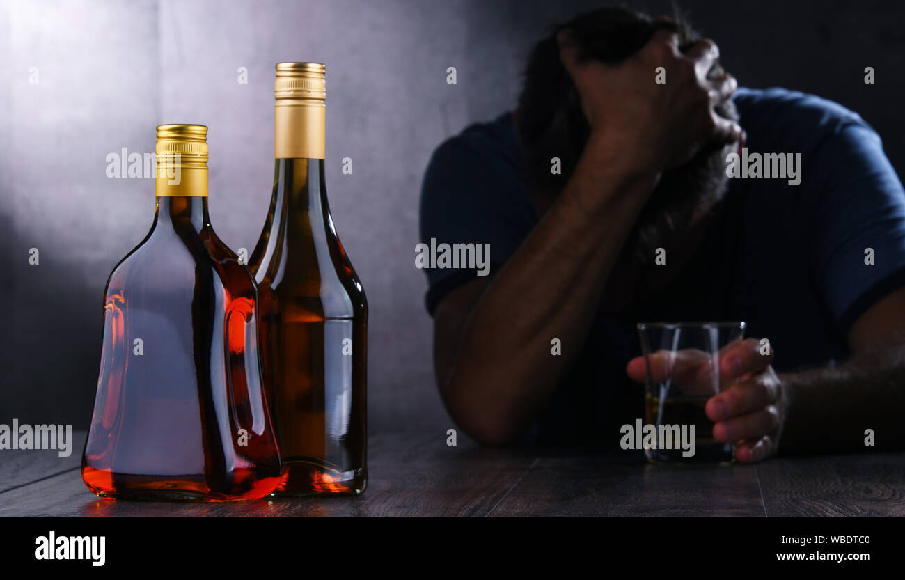 Flaschen mit alkoholischen Getränken und die Abbildung von einem betrunkenen Mann Stockfoto
