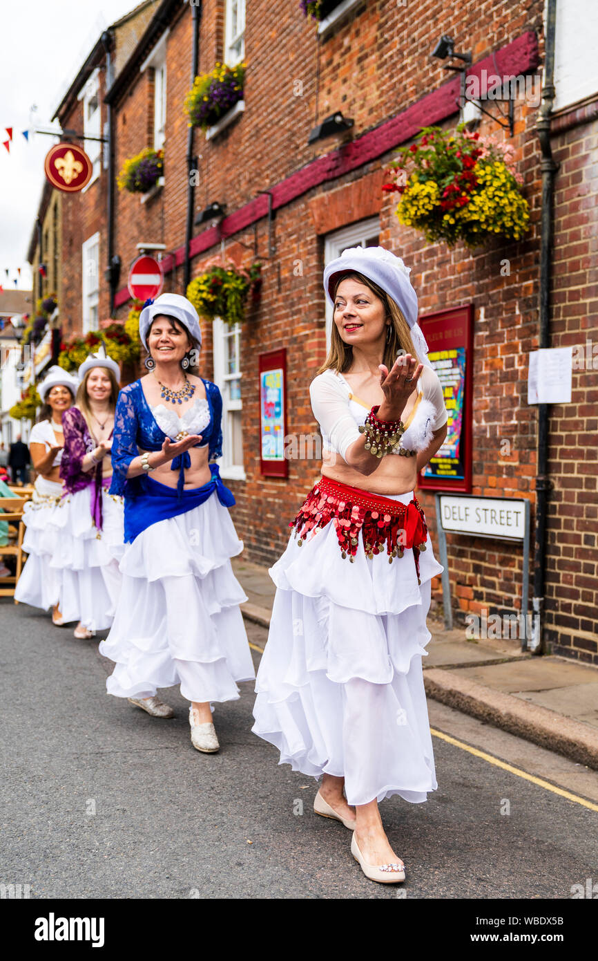 Sandwich Folk und Ale-Festival. Reife Frauen des Gutes Karma Damen Bauchtänzerinnen Tanz draußen auf der Straße in weißen Kleidern und Hüten. Stockfoto