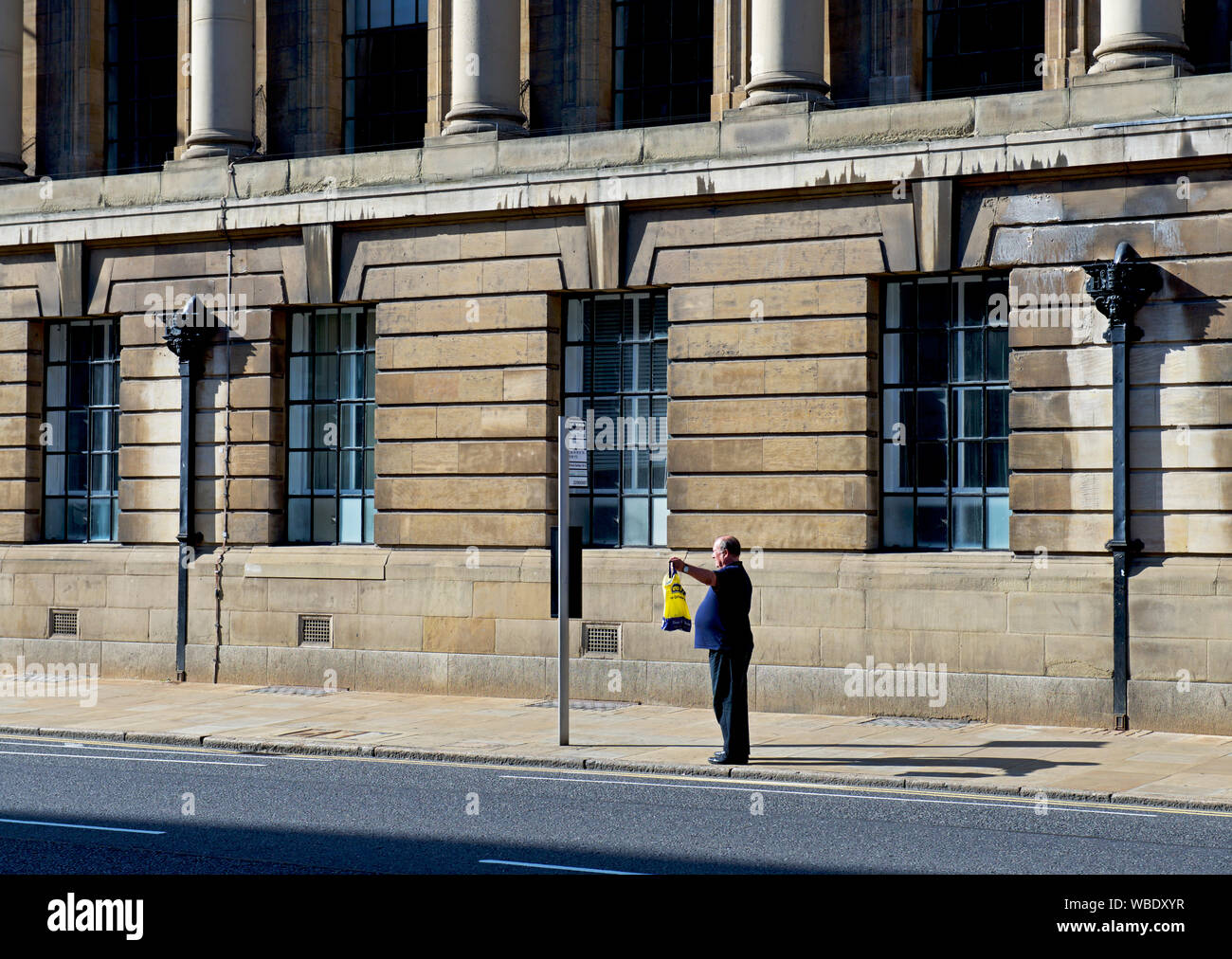 Mann hageln Bus außerhalb der Guildhall, auf Alfred Gelder Straße, Hull, East Yorkshire, England, Großbritannien Stockfoto