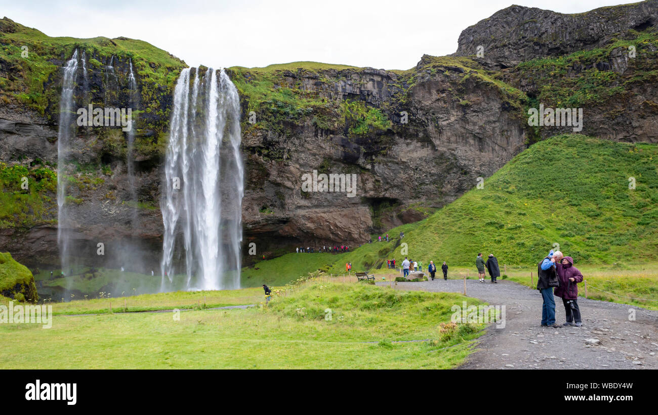 Leute, Touristen und Reisende besuchen die Wasserfall Seljalandsfoss, Island. Stockfoto