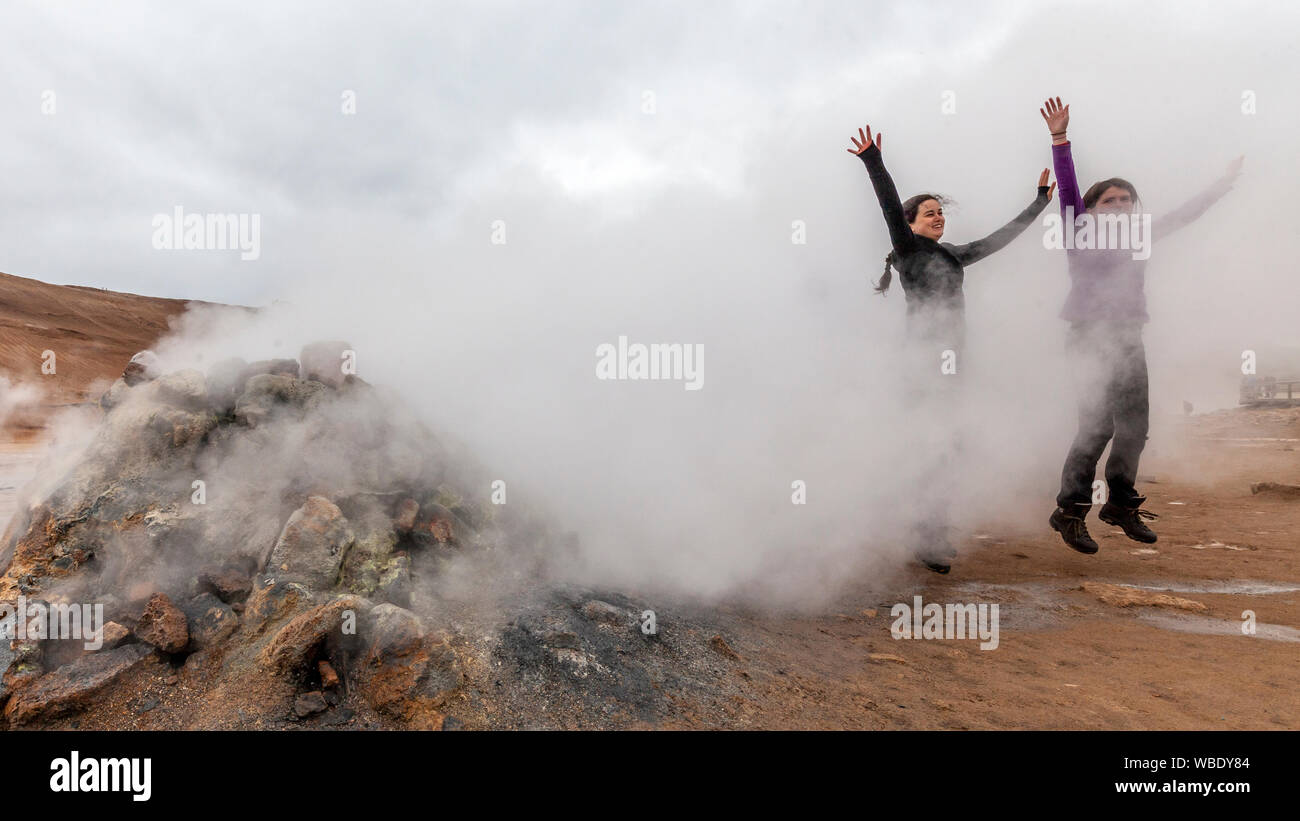 Zwei Frauen Spaß springen in der Dampf an der Hverir geothermische Feld von Mt. Neben dem See Myvatn Namafjall, Island. Stockfoto