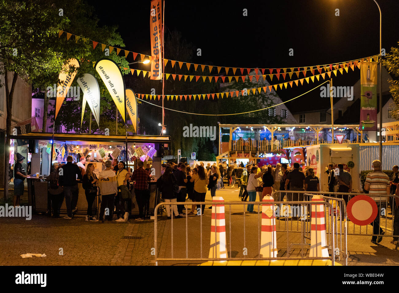 Stadtfest Brugg 24. august 2019. street photography. Hot-Shots-Bar in beleuchtete Stadt Teil mit bunten Wimpel, viele Menschen und Sicherheit Poller Stockfoto