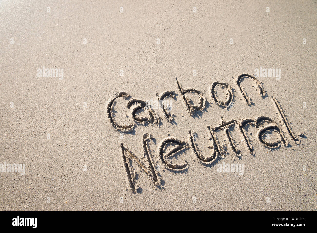 Co2-neutral Nachricht handschriftlich auf glatten Sandstrand Stockfoto