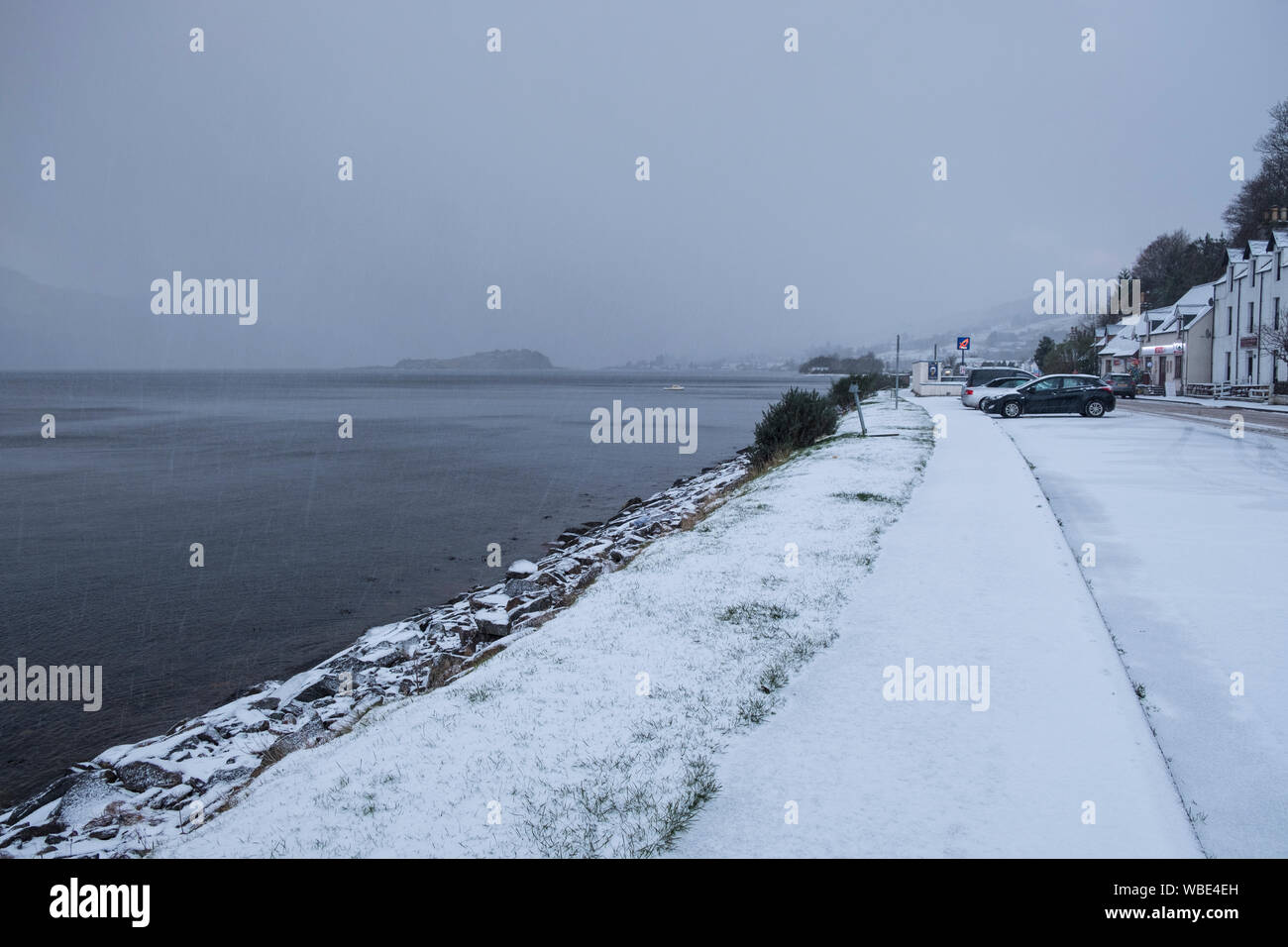 Main Street, Lochcarron, Blick nach Westen in Richtung des Dorfes Shop und Tankstelle. Sleeting mit lag Schnee auf der Straße und der Gehwege durch die LOCHSIDE. Stockfoto