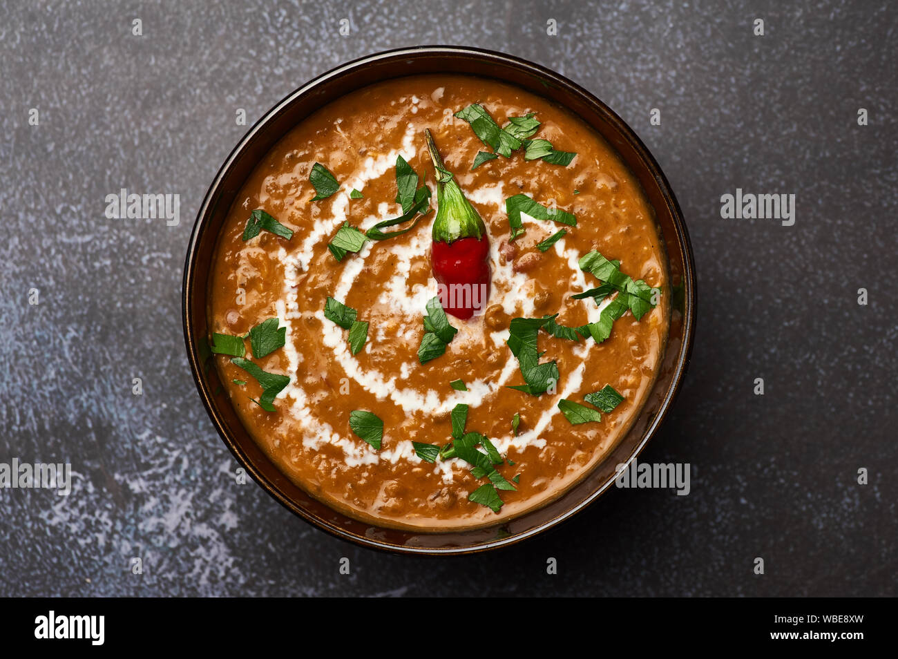 Dal Makhani auf dunklem Hintergrund. Dal Makhani - Traditionelle indische Küche Püree Gericht mit urad Bohnen, rote Bohnen, Butter, Gewürze und Sahne. Stockfoto