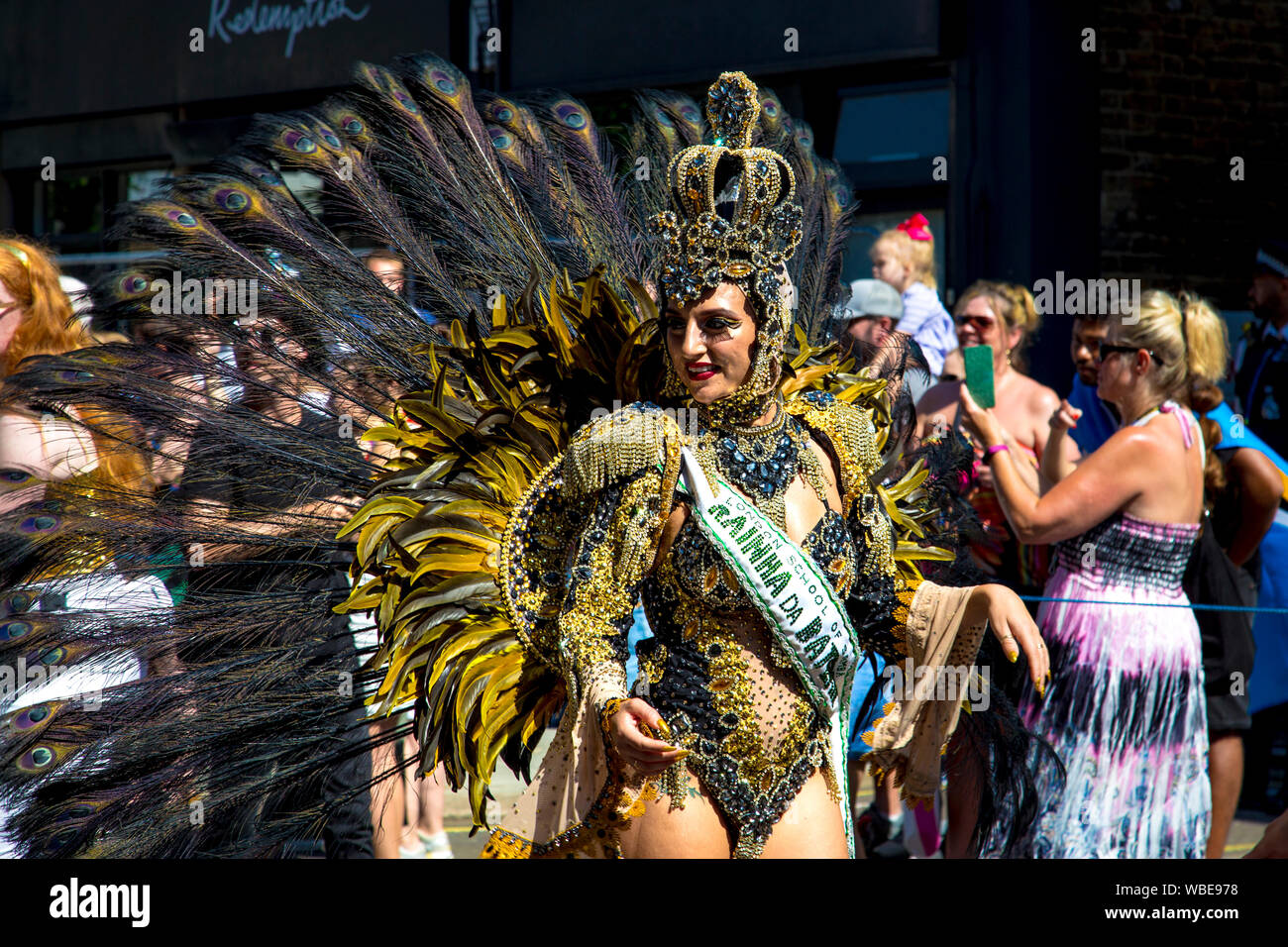 26. August 2019 - Samba Tänzerin tragen Kostüm mit Krone Kopfschmuck, pfauenfedern an Notting Hill Karneval an einem heißen Feiertag Montag, London, UK Stockfoto