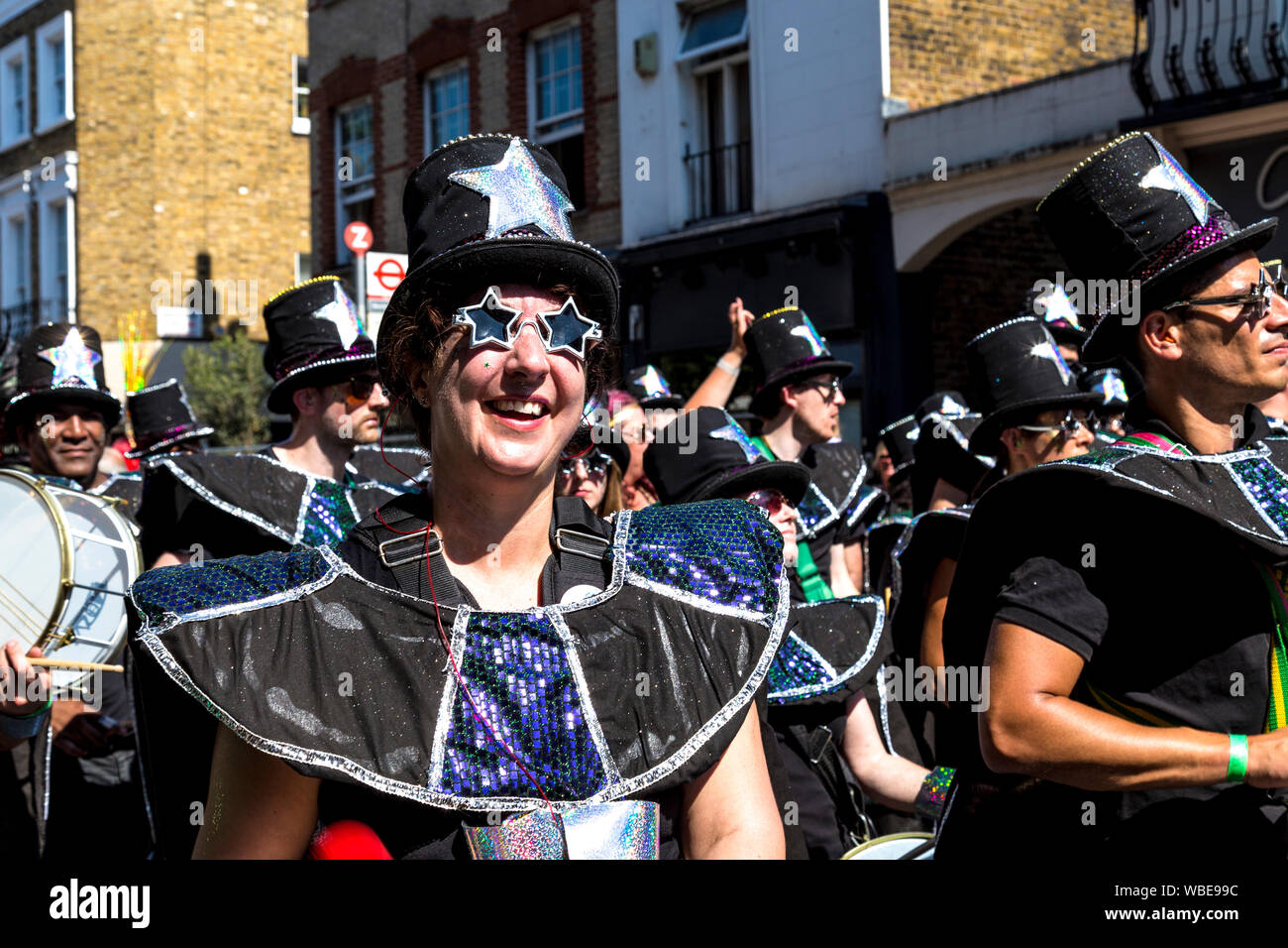 26. August 2019 - die Frau, die in einer Blaskapelle tragen sternförmige Sonnenbrille am Notting Hill Carnival an einem heißen Feiertag Montag, London, UK Stockfoto