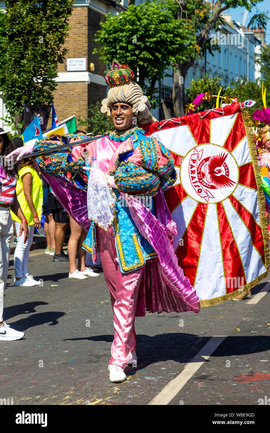 26. August 2019 - Mann, gekleidet in einen Zeitraum Kostüm mit Pulver Perücke, Krone und Flagge in Notting Hill Karneval an einem heißen Feiertag Montag, London, UK Stockfoto