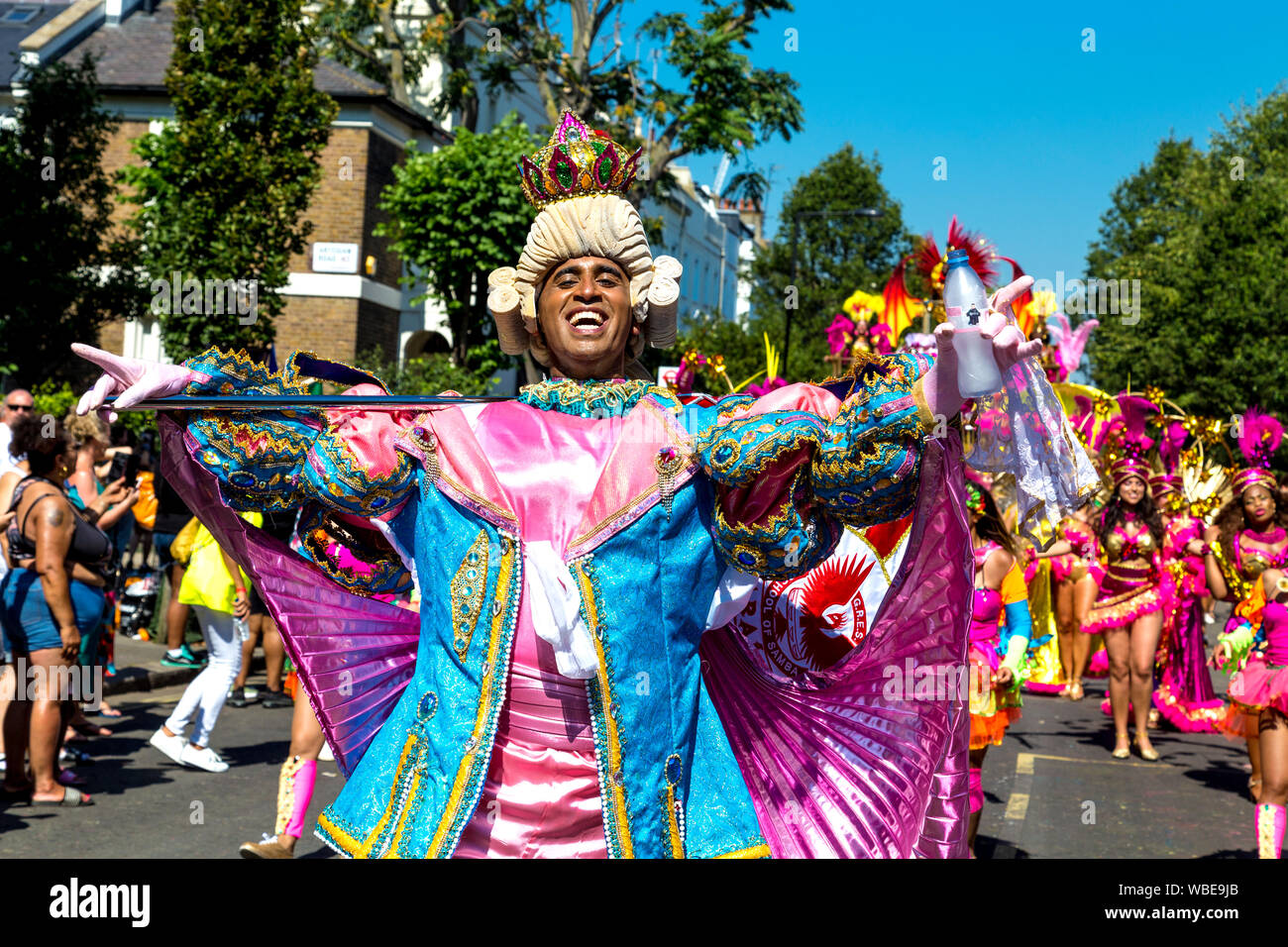 26. August 2019 - Mann, gekleidet in einen Zeitraum Kostüm mit Pulver Perücke, Krone und Flagge in Notting Hill Karneval an einem heißen Feiertag Montag, London, UK Stockfoto