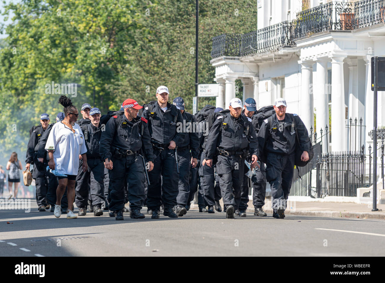 Polizei Verstärkungen kommen an der Notting Hill Carnival abschließende Parade an einem heißen Feiertag Montag. Die Zahl der Polizisten anreisen Stockfoto