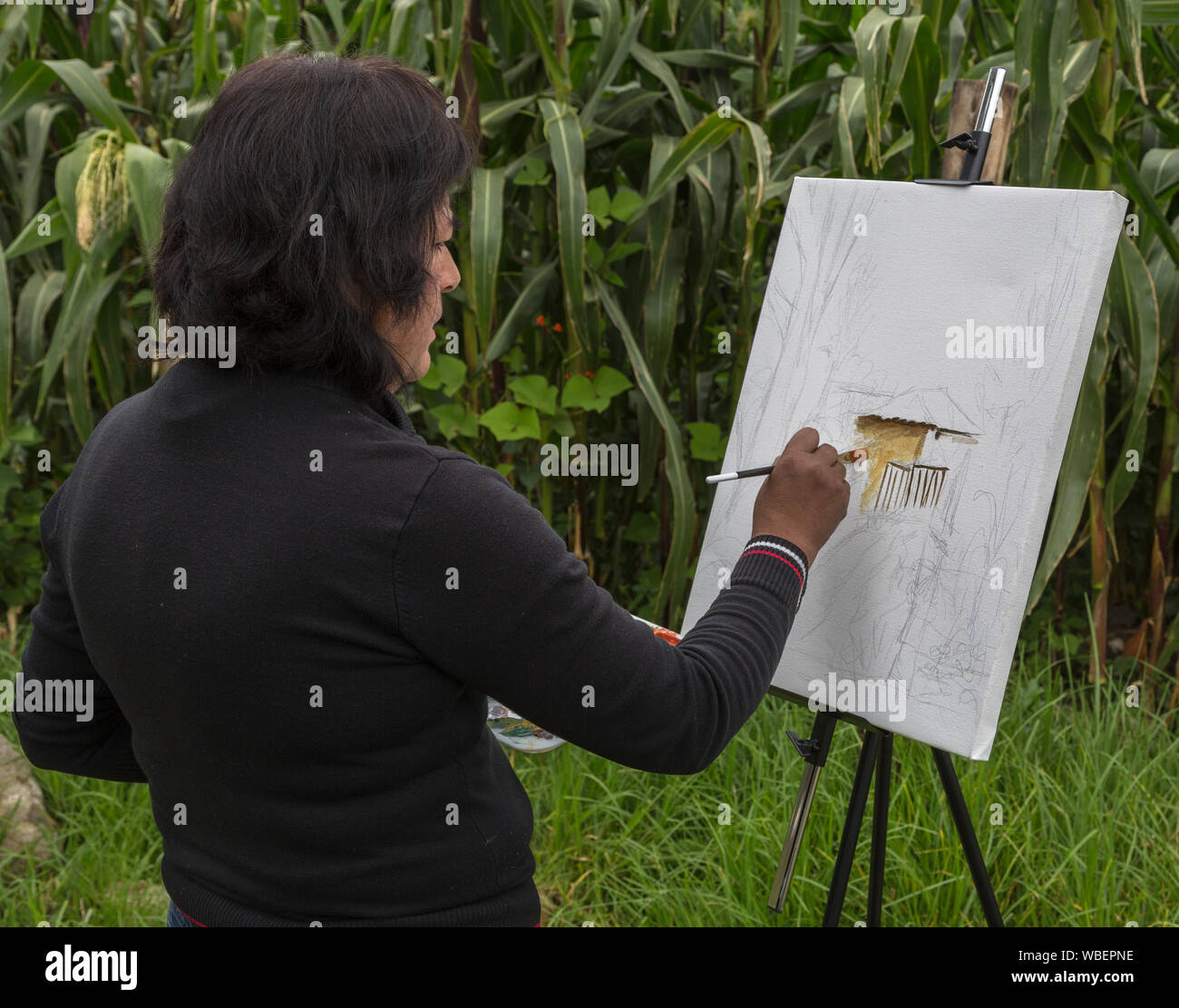 Pacha, Ecuador - Mar 23, 2014: Frau malt auf staffelei plein Aire Stockfoto