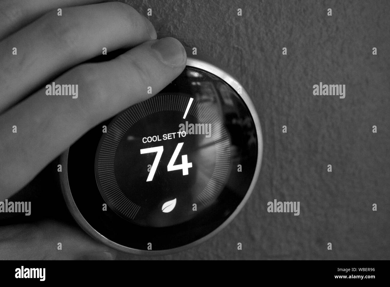 Hand Einstellen der Temperatur auf smart Thermostat - Green Tech! Sparen Sie Strom. Schwarz und Weiß. Stockfoto