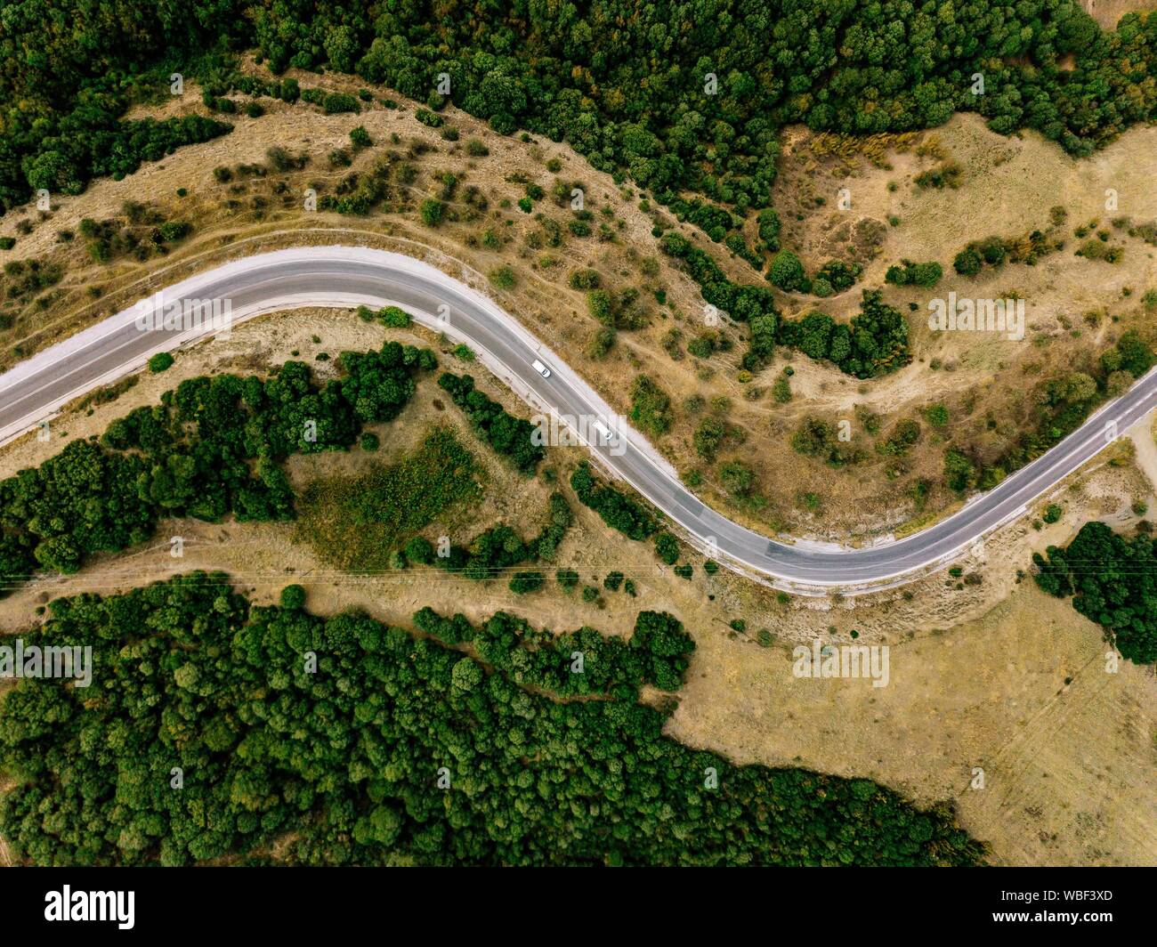 Antenne oben Ansicht einer ländlichen Landschaft mit einer kurvigen Straße durch ihn läuft in Griechenland. Drone Fotografie Stockfoto
