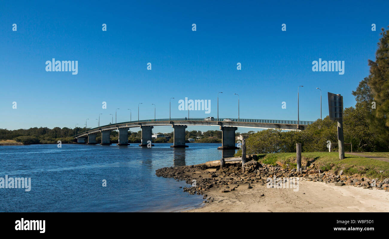 Elegant gewölbte Verkehr Brücke über den blauen Wassern des Myall River mit ufer bäume steigen in den blauen Himmel bei Tea Gardens, NSW Australien Stockfoto