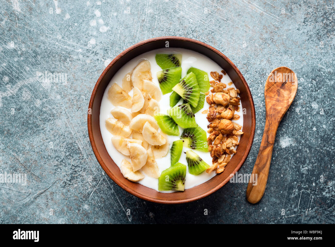 Joghurt Schale mit tropischen Früchten Kiwi, Banane und Müsli. Ansicht von oben Stockfoto