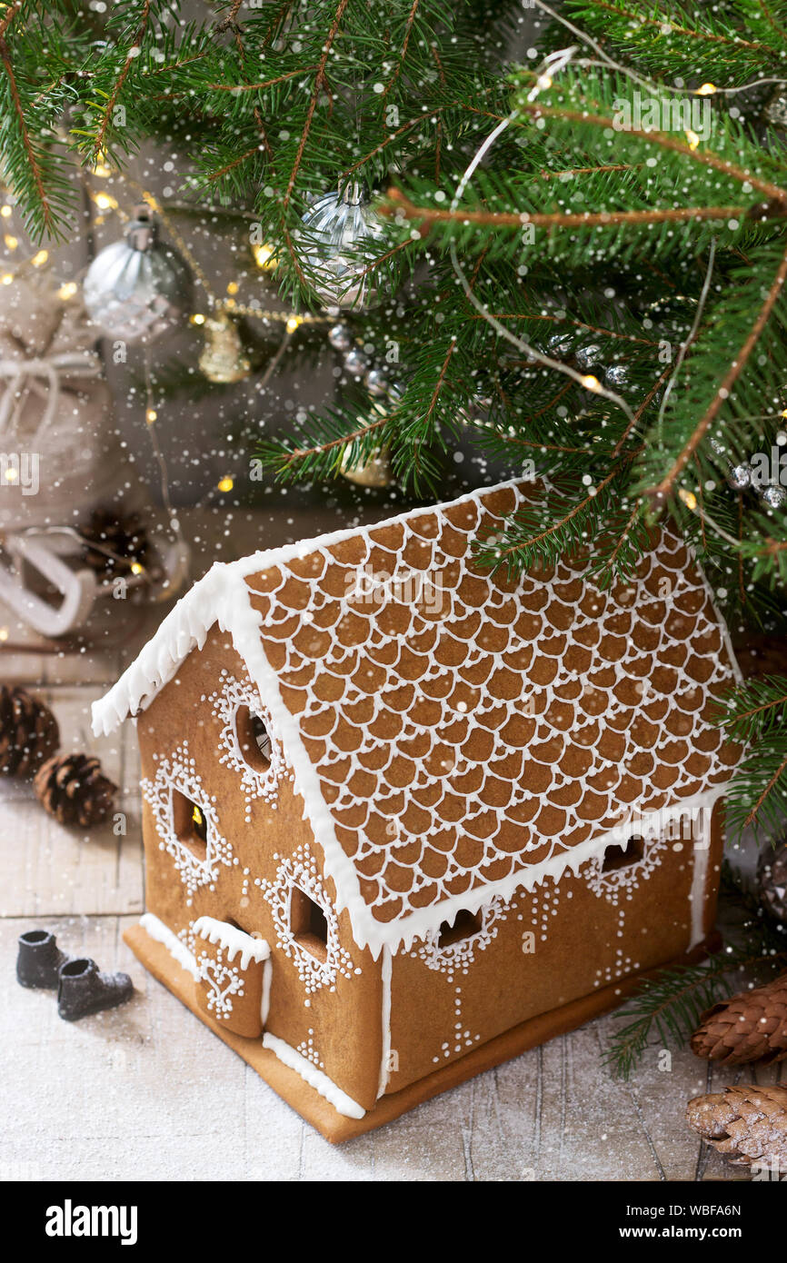 Lebkuchenhaus und Weihnachtsbäume auf einen hellen Hintergrund. Bokeh Wirkung. Stockfoto