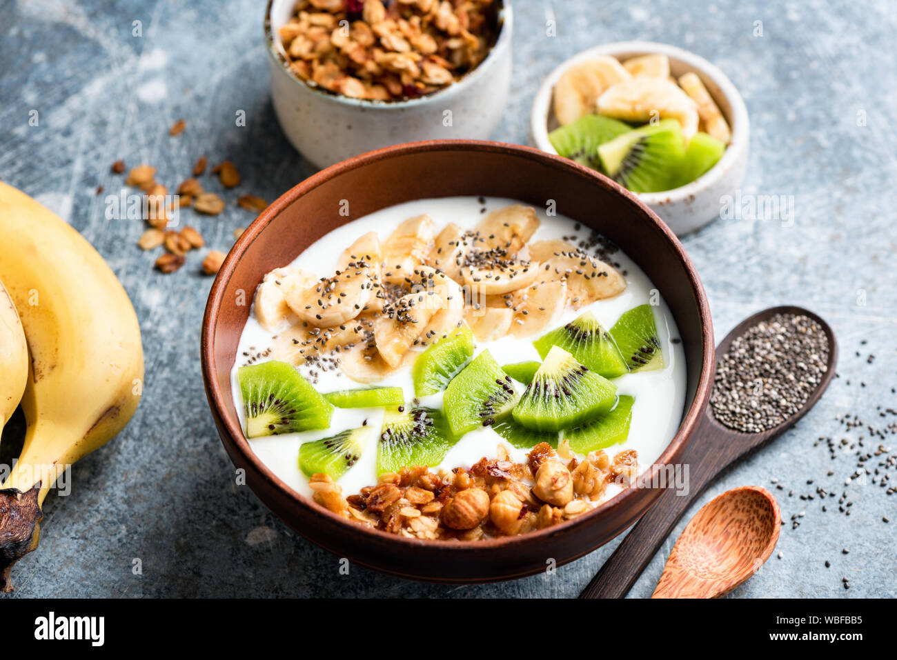 Obst Müsli Joghurt Schale mit Chia Samen für ein gesundes Frühstück oder einen Snack. Kiwi, Banane, Haferflocken Müsli und griechischer Joghurt in der Schüssel gemischt. Gesunde Ernährung Stockfoto