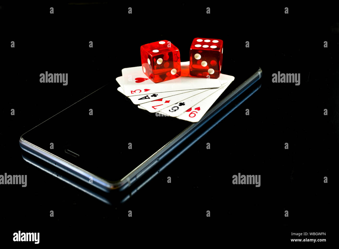 Handy auf schwarzen Hintergrund mit mehreren Karten und roten Würfel auf dem Display, konzeptionelle Bild über Mobile Game Industry Stockfoto
