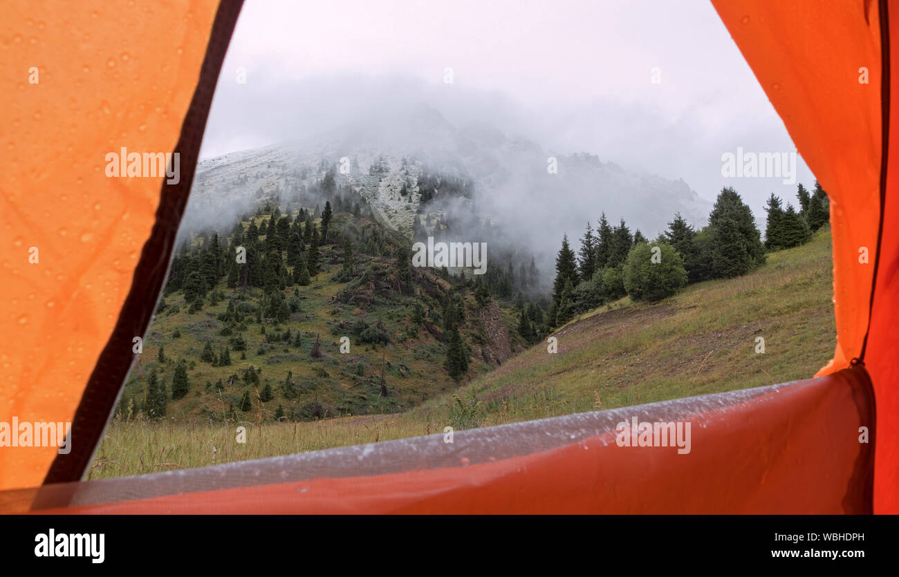 Blick aus dem Zelt zu Berg mit frisch gefallenen Schnee bei Nebel bedeckt; Ende der Sommersaison Konzept Stockfoto