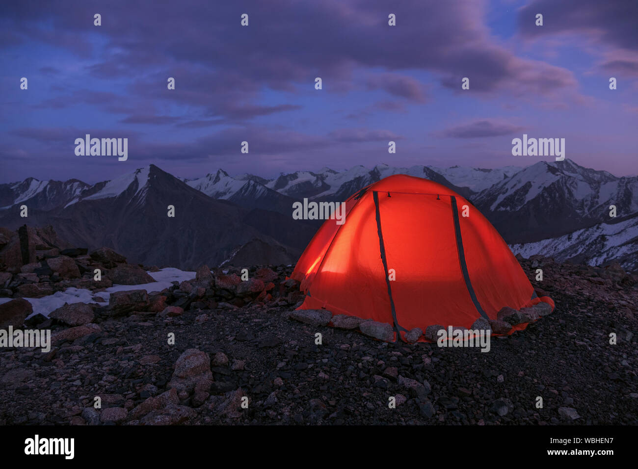 Safe Travel Concept: Zelt hoch in den Bergen eingestellt ist verstärkt, um den Perimeter mit Steinen für Stabilität bei starker Wind. Tian Sh Stockfoto