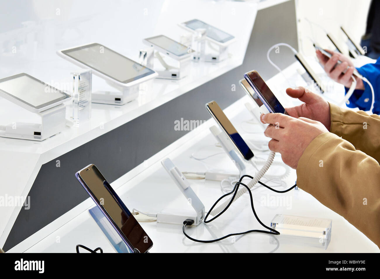 Käufer Hände mit mobilen Smartphones in einem Elektronikfachgeschäft Stockfoto