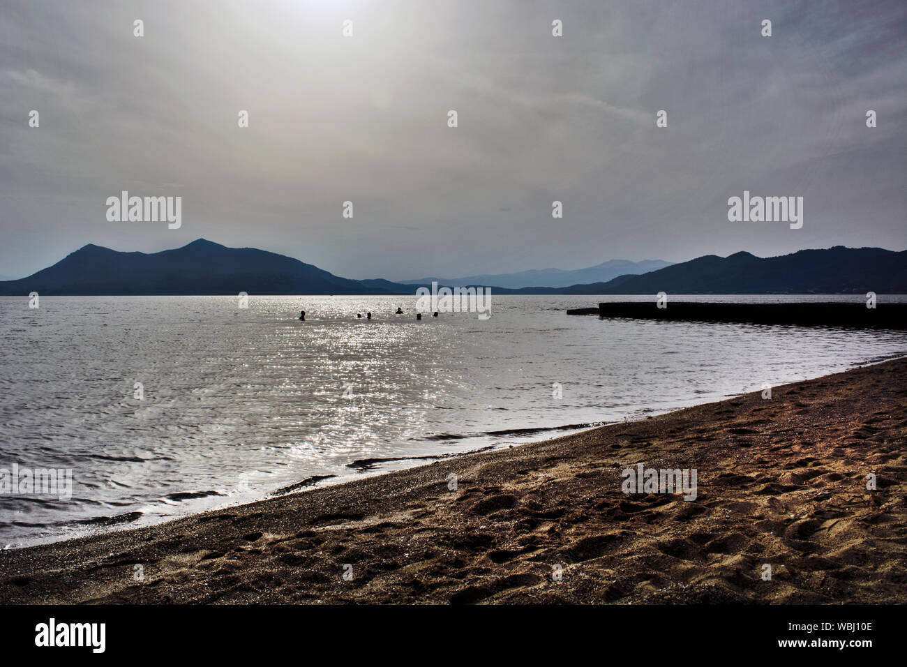 Eine Gruppe von Schwimmern in Griechenland im Meer baden vor Sonnenuntergang. Stockfoto