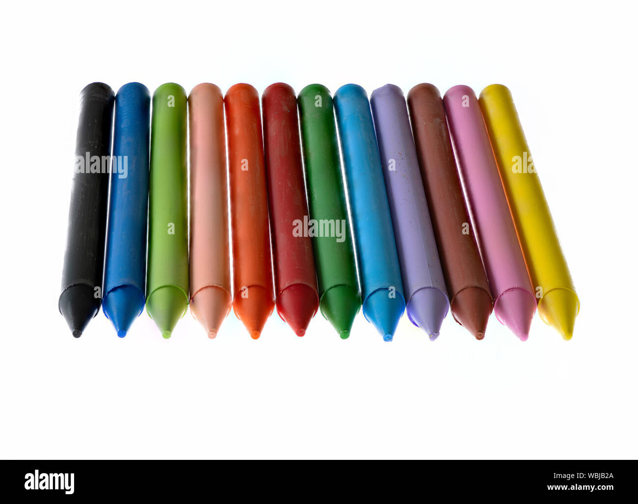 12 mehrfarbige Wachsmalstifte vor einem weißen Hintergrund Stockfoto