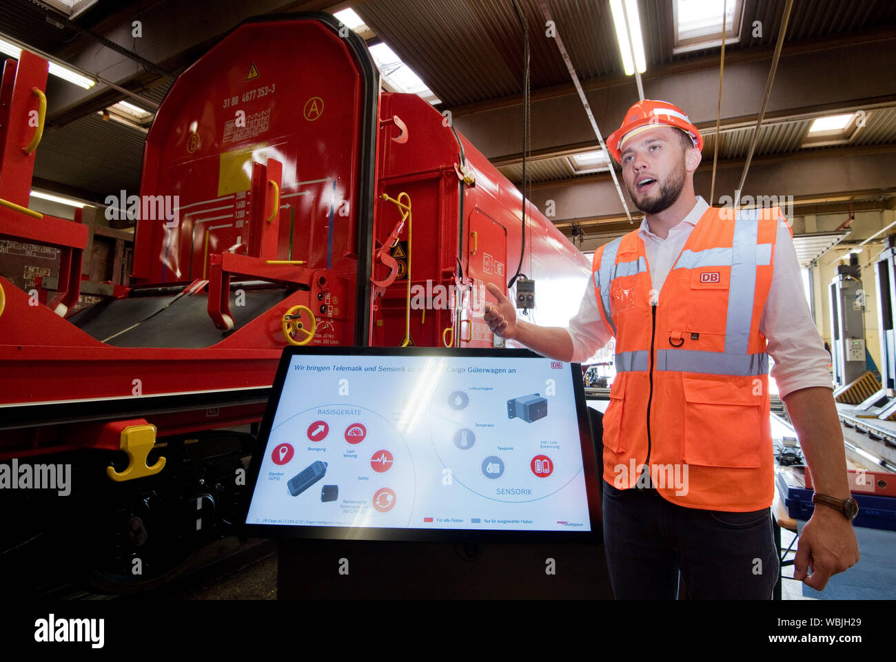 Seelze, Deutschland. 27 Aug, 2019. Gerrit Koch zu Krax, Projektleiter intelligenter Güterwagen der DB Cargo, erklärt die moderne Sensorik auf einer Presseveranstaltung der Deutschen Bahn Cargo. Deutsche Bahn forciert die Digitalisierung der Güterwagen Flotte bei voller Drehzahl: 34.000 Wagen sind bereits mit den neuesten Telematik und intelligente Sensoren ausgestattet. Im Jahr 2020 wird die gesamte Flotte von rund 68.000 Autos in Deutschland wird Digital reisen werden. Credit: Julian Stratenschulte/dpa/Alamy leben Nachrichten Stockfoto