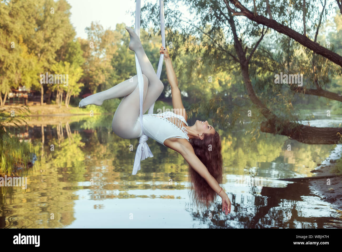 Porträt einer wunderschönen Acrobat Mädchen. Sie Tricks auf Leinwänden über dem Fluss. Stockfoto