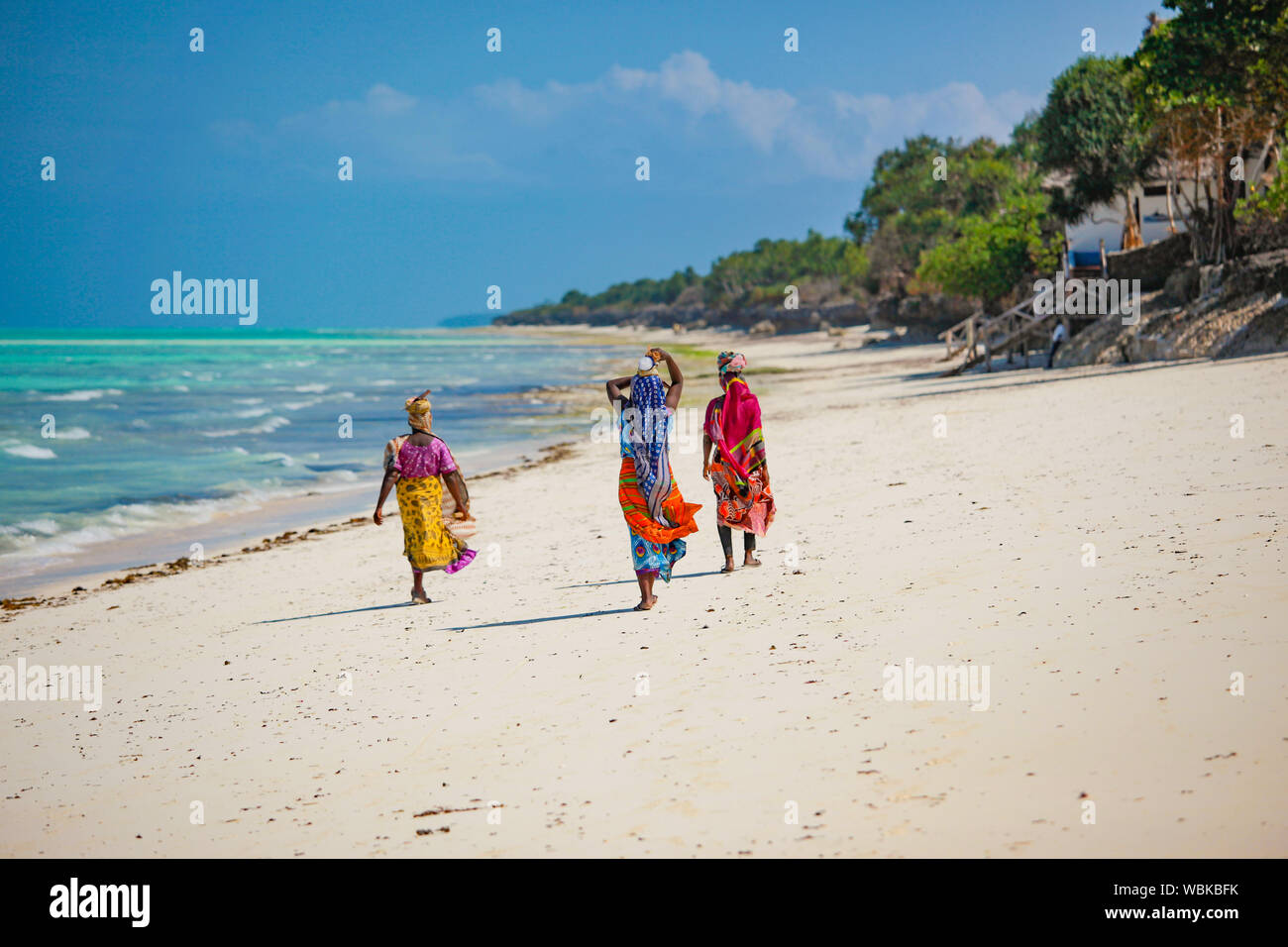 Zanzibar Beach muslimischen Frauen in nationalen helle Kleidung am Strand spazieren gehen Stockfoto