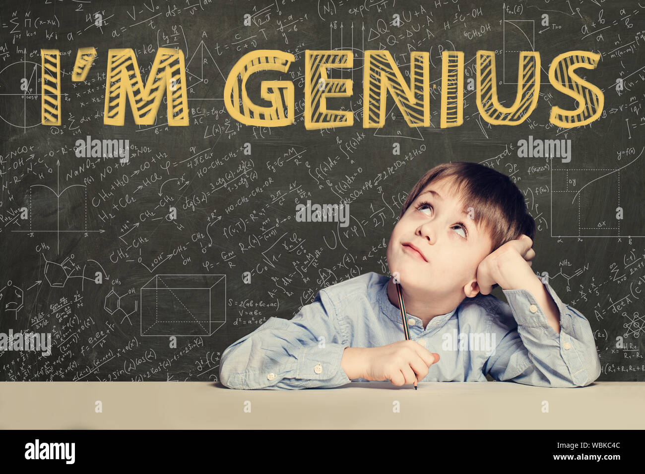 Glückliches Kind Student auf blackboard Hintergrund mit Wissenschaft und Mathematik Formel Stockfoto