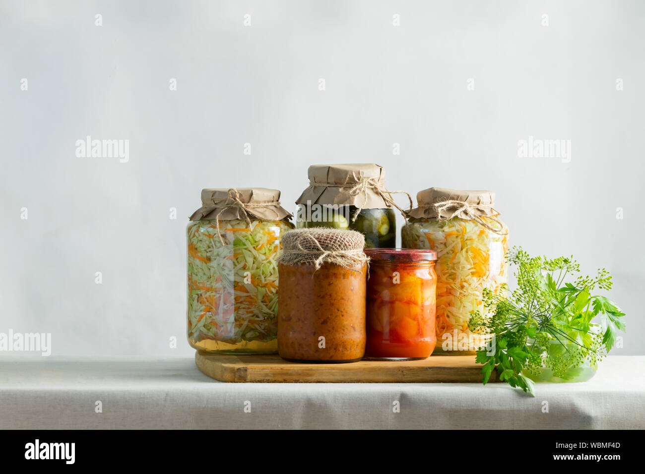 Fermentierte oder canning verschiedene Gemüse zucchini Möhren sauerkraut Gurken in Gläsern auf einem Tisch. Verarbeitung der Herbst Ernte. Natürlichen rustikalen Stil Stockfoto