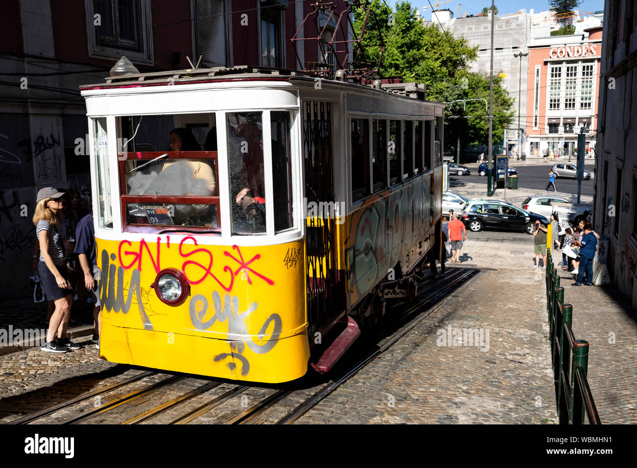 Touristische boarding ein Graffiti bedeckt Standseilbahn Straßenbahn, Lissabon, Portugal. Stockfoto