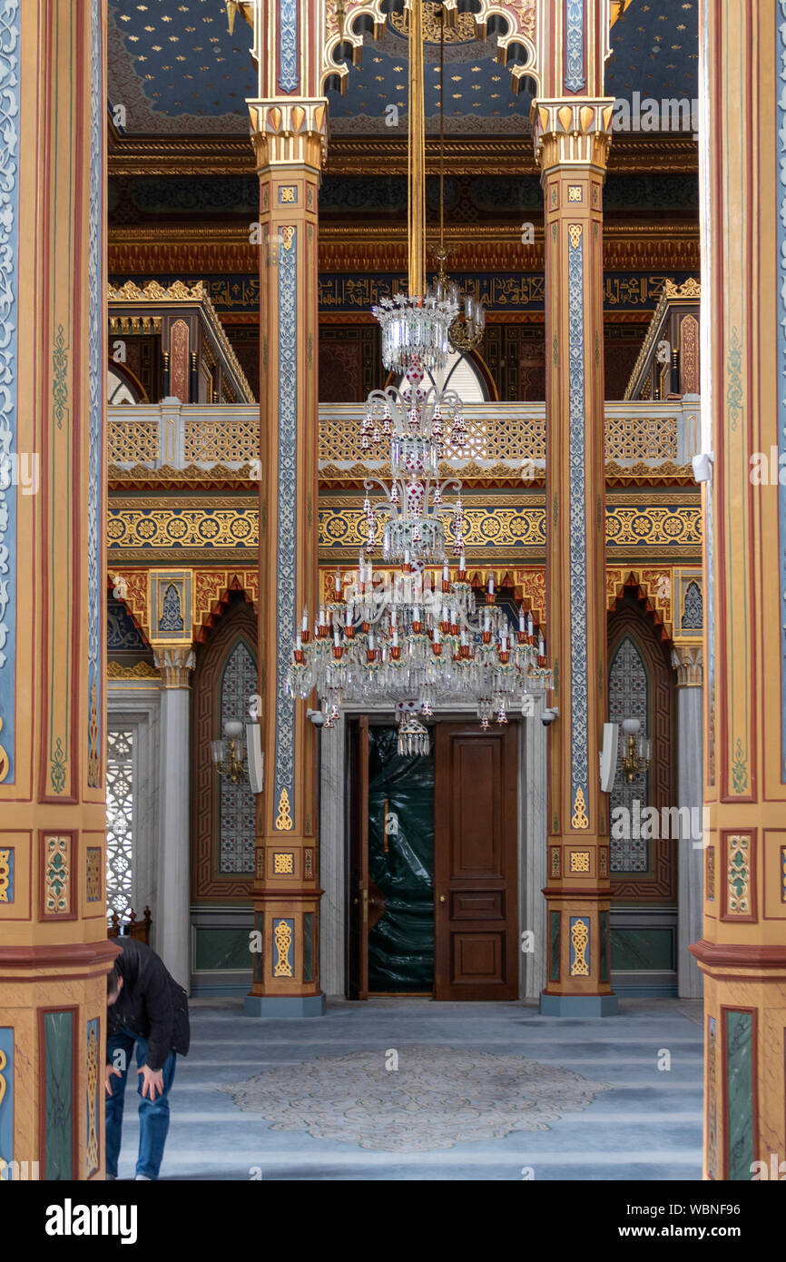 Vergoldete historische Moschee innen und der Mann, der betet. Stockfoto