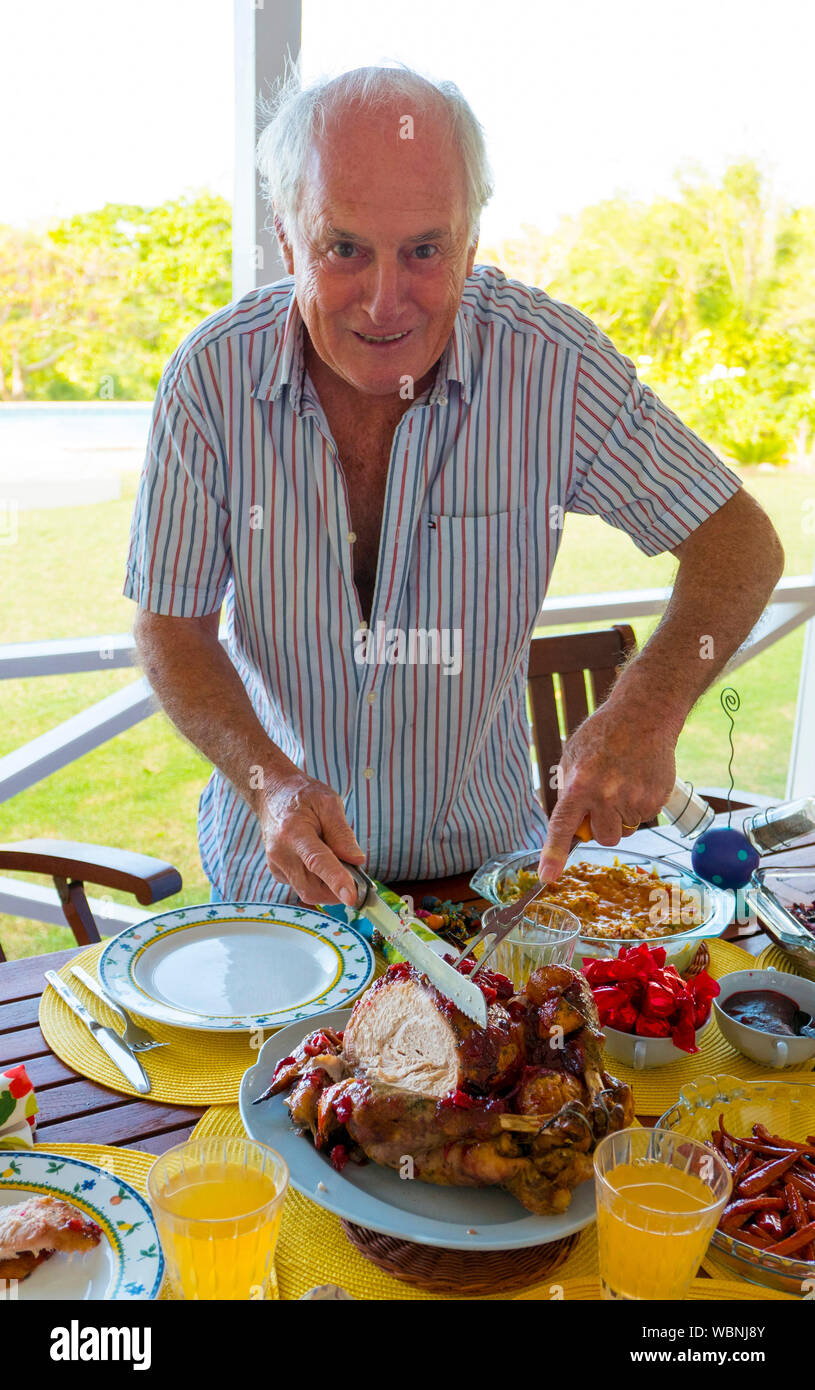 Mann schnitzen das Xmas Türkei über die Mittagszeit Tabelle in der Karibik. Stockfoto