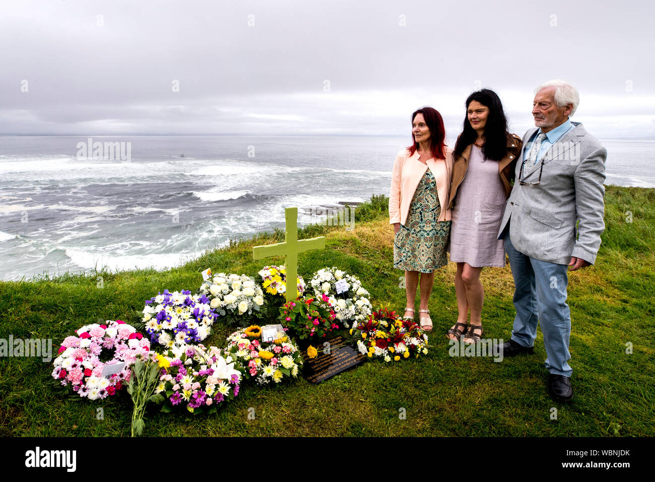 Als Teil des Services zum 40. Jahrestag mit Blick auf den Hafen von Mullaghmore, Co Sligo; John Maxwell und Mary Hornsey mit ihrer Tochter Lisa McKean. Nachdem sie ihrem Sohn Paul Maxwell einen Kranz hinterlassen hatten, der am 27. August 1979 vor der Küste von Mullaghmore von der IRA in die Luft gesprengt wurde, als Lord Mountbattens Boot getötet wurde. Stockfoto